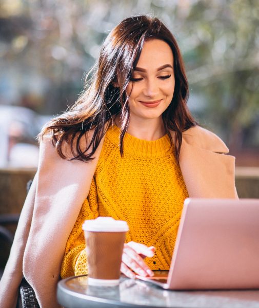 Business woman working on a computer and drinking coffee